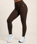 Coffee brown leggings worn by a person on a beige background