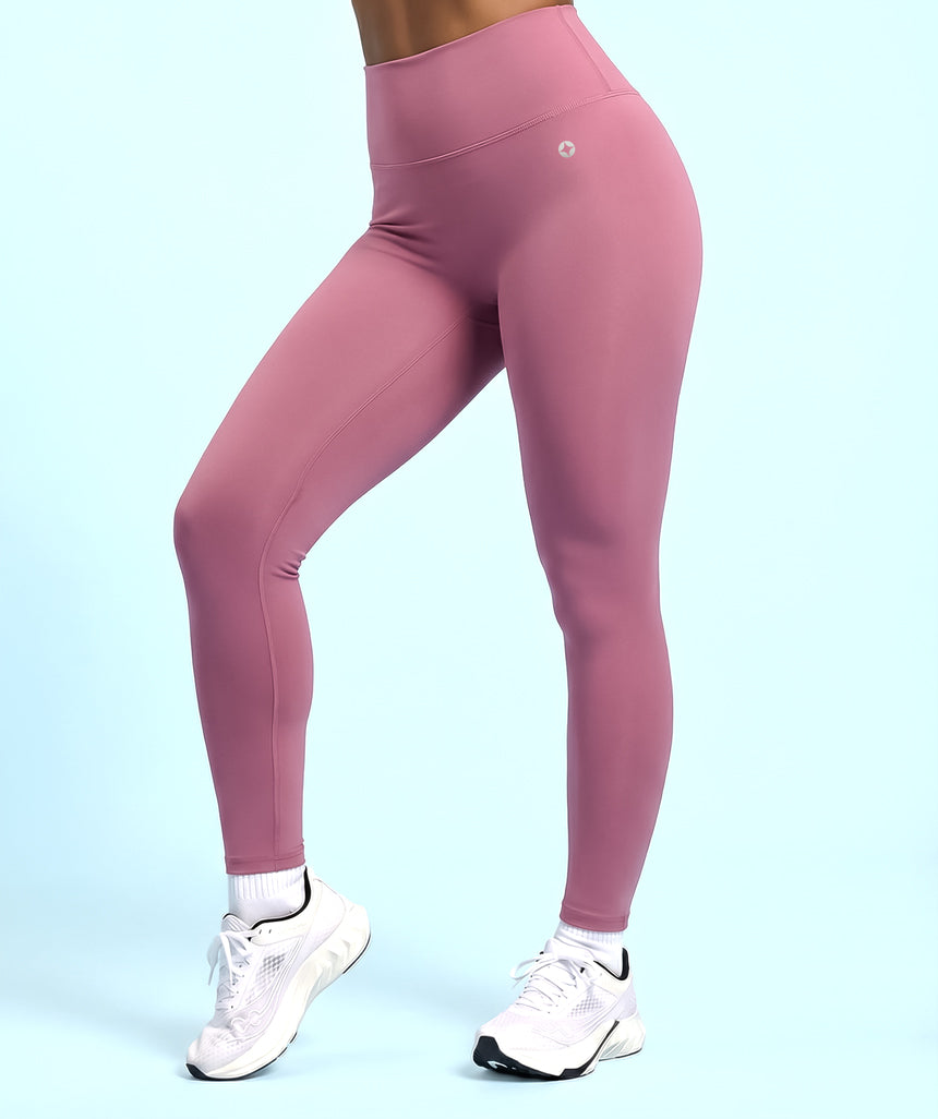 Dusty rose pink leggings worn by model on a light blue background