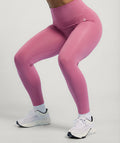 Dusty rose pink leggings worn by a person on a light gray background