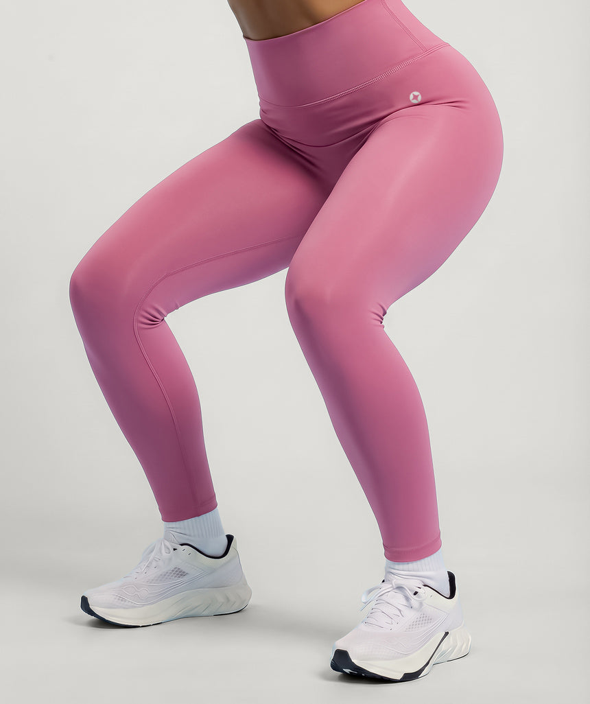 Dusty rose pink leggings worn by a person on a light gray background