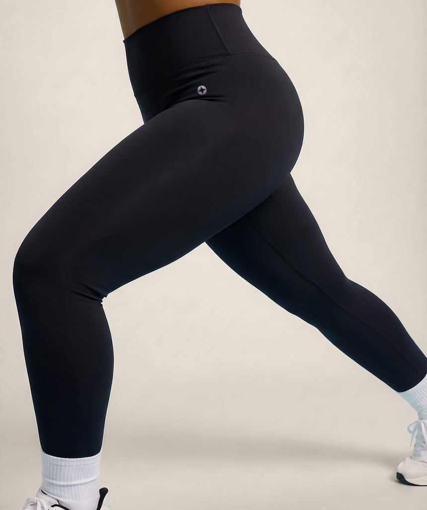 Black leggings worn by a female model on a plain background
